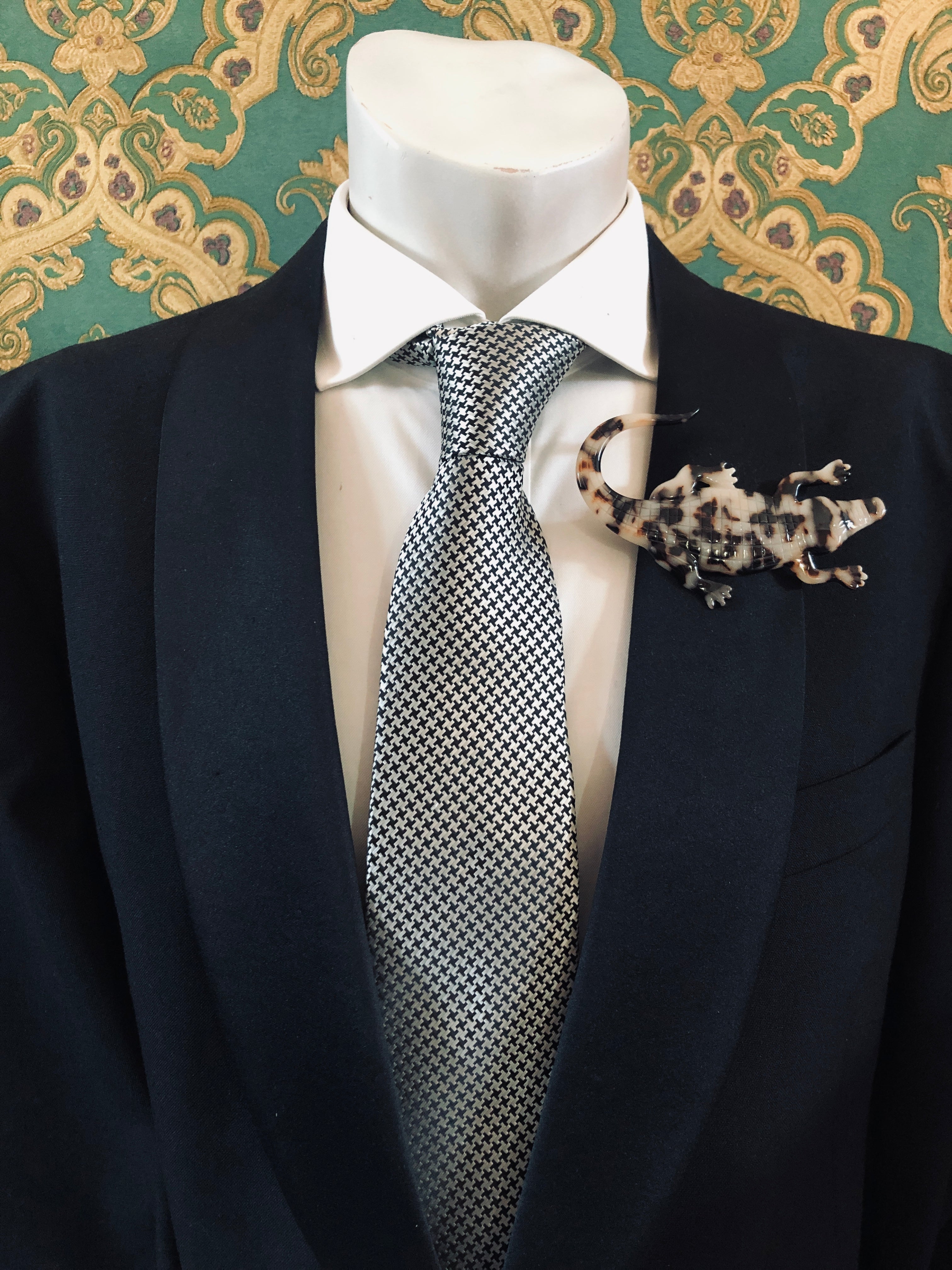 Men's alligator brooch in brown tortoiseshell acetate worn on a black tailored jacket with silver houndstooth tie, from the Broochella Animalia Collection.