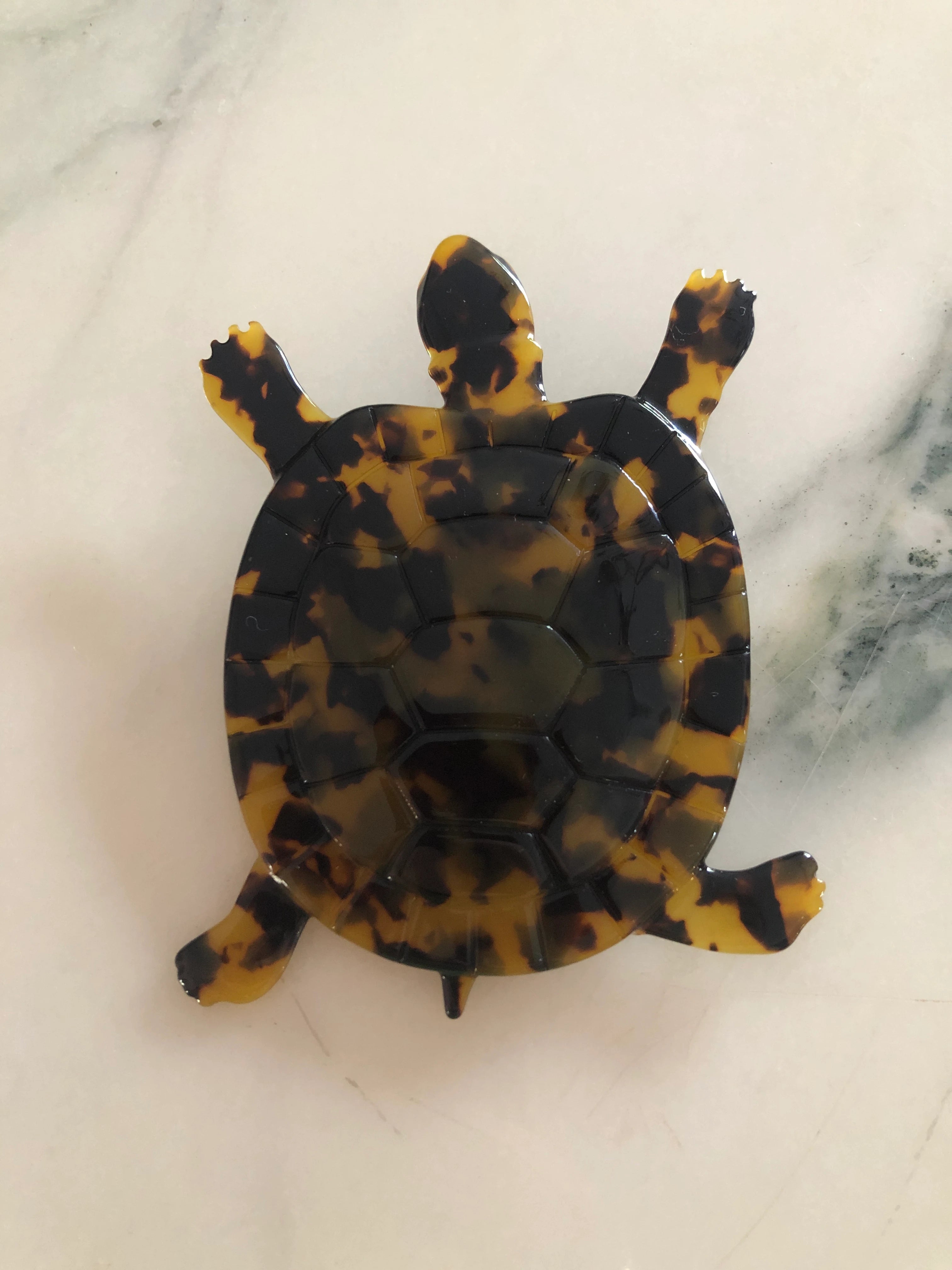Broochella Men's brown Animalia tortoiseshell giraffe shaped brooch. It is made from Premium Italian cellulose tortoiseshell acetate. The background is white marble.