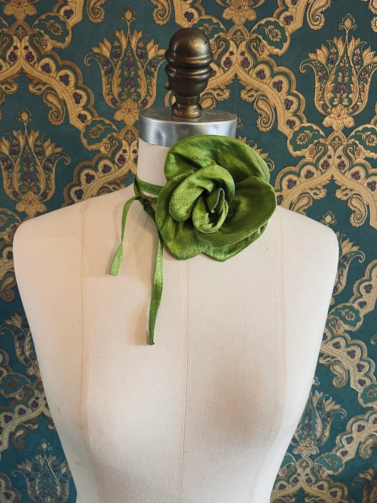 Broochella Bellucci small chartreuse handmade silk flower brooch and choker  Pictured on a mannequin. The background is green and gold damask wallpaper