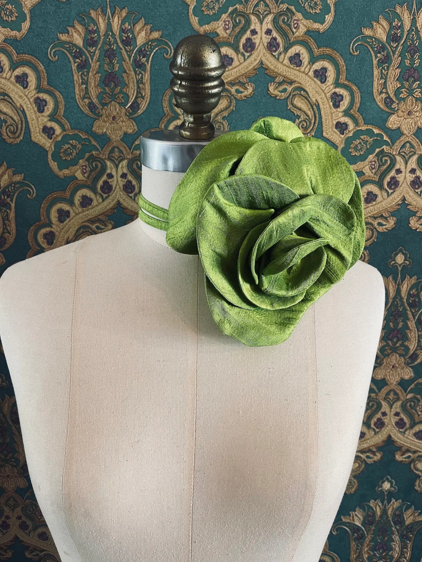 Broochella Bellucci large chartreuse handmade silk flower brooch and choker  Pictured on a mannequin. The background is green and gold damask wallpaper.