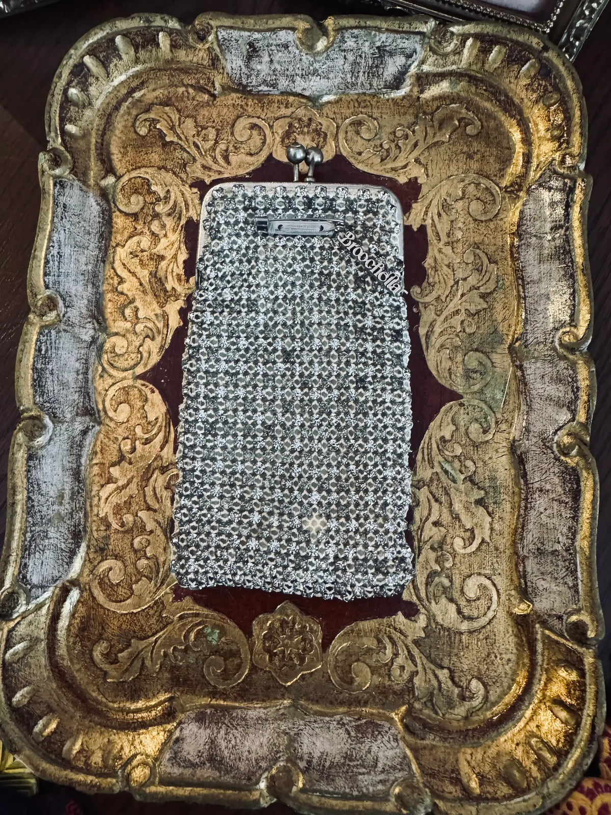 Mannequin wearing a black coat with a sparkling handbag and white shirt with decorative collar. It is wearing the Broochella Borsellino vintage crystal purse brooch. 