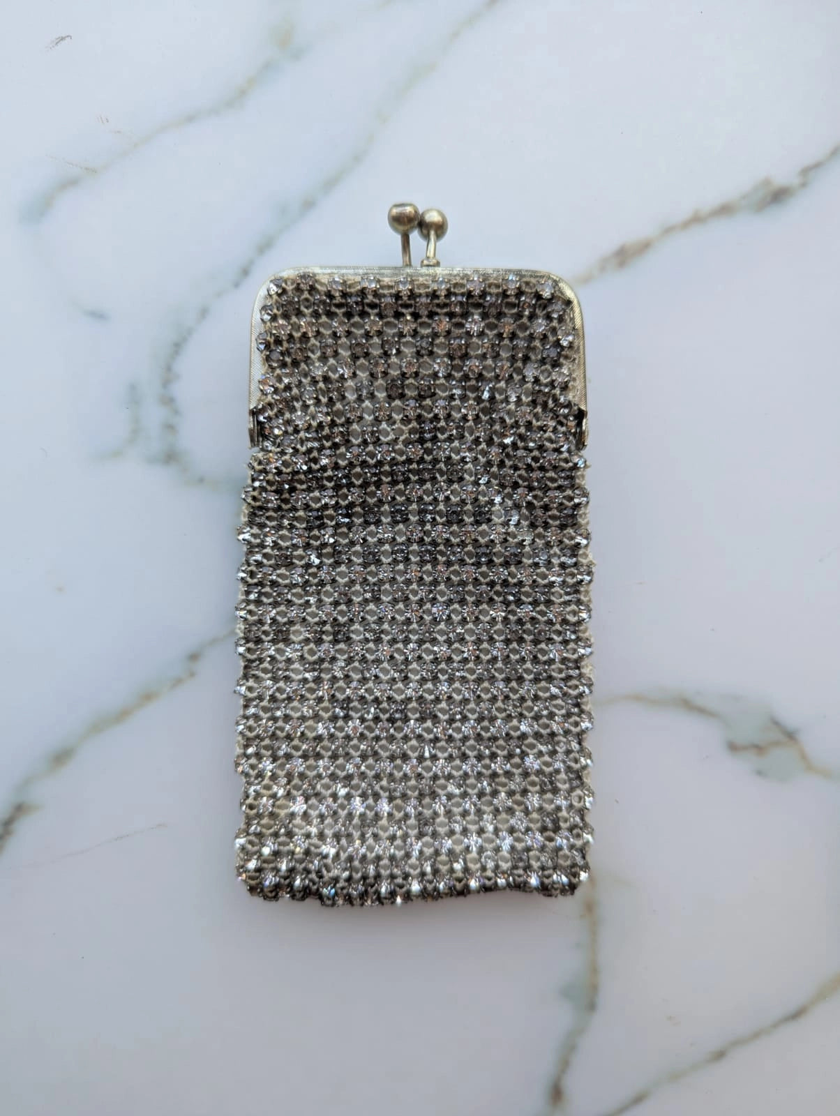 Mannequin wearing a black coat with a sparkling handbag and white shirt with decorative collar. It is wearing the Broochella Borsellino vintage crystal purse brooch. 