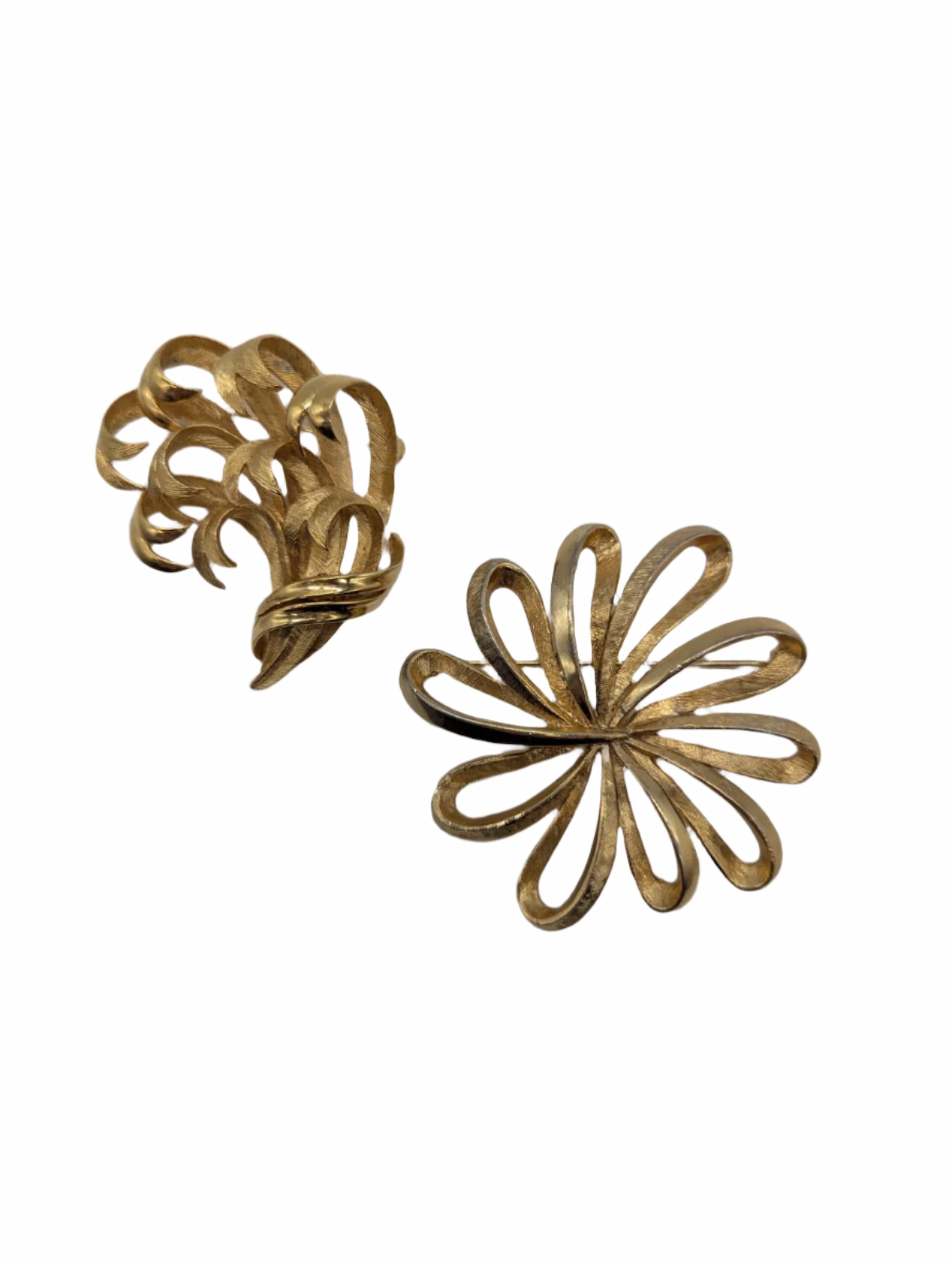 Two gold floral-shaped Broochella boucle bloom vinatge brooch set on a white background
