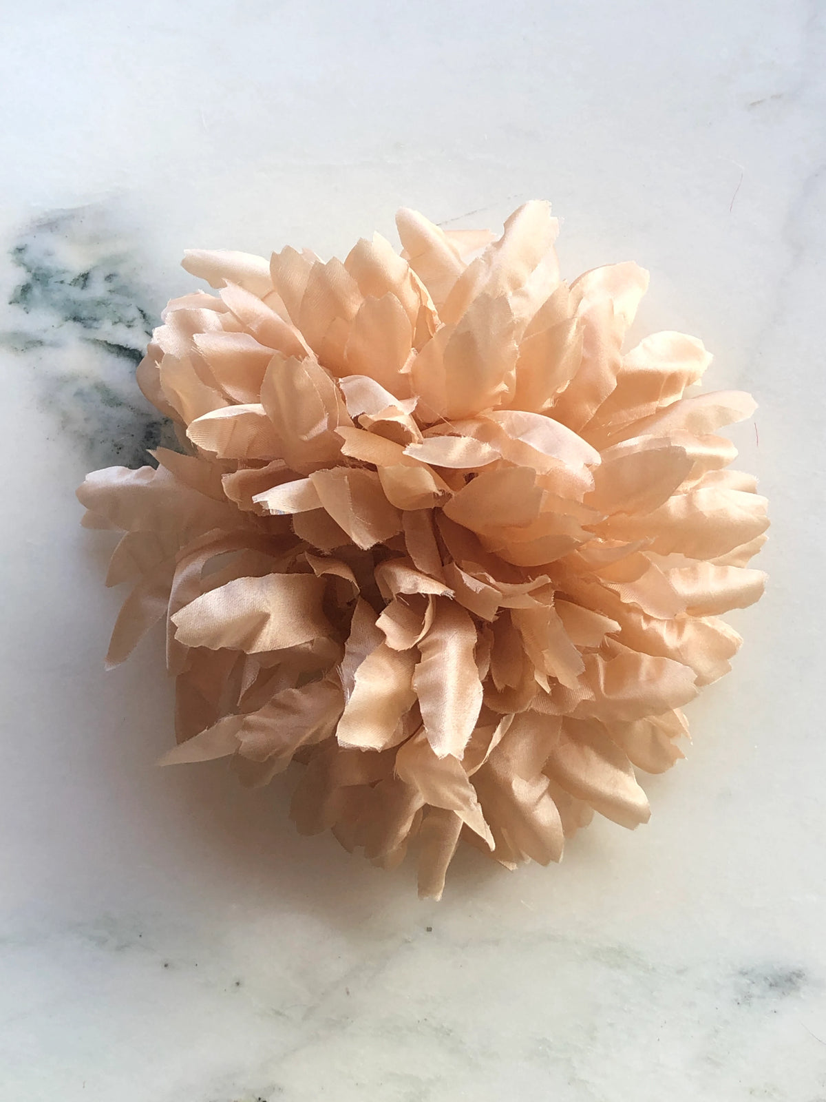 Broochella Men's Calendula Handmade Flower Brooch featuring layered grey fabric petals in a full sculptural floral design, photographed on a cream marble background.