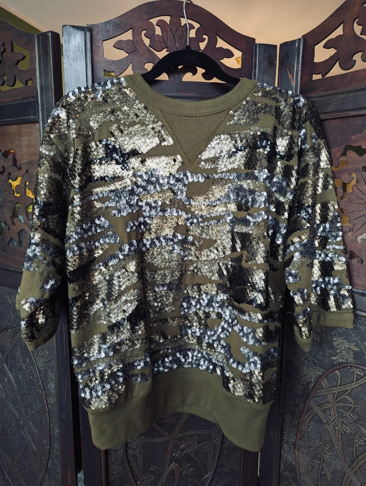 Broochella Isabel Marant Green Sequin Jumper- 38. Pictured hanging over an ornate dark wook room divider