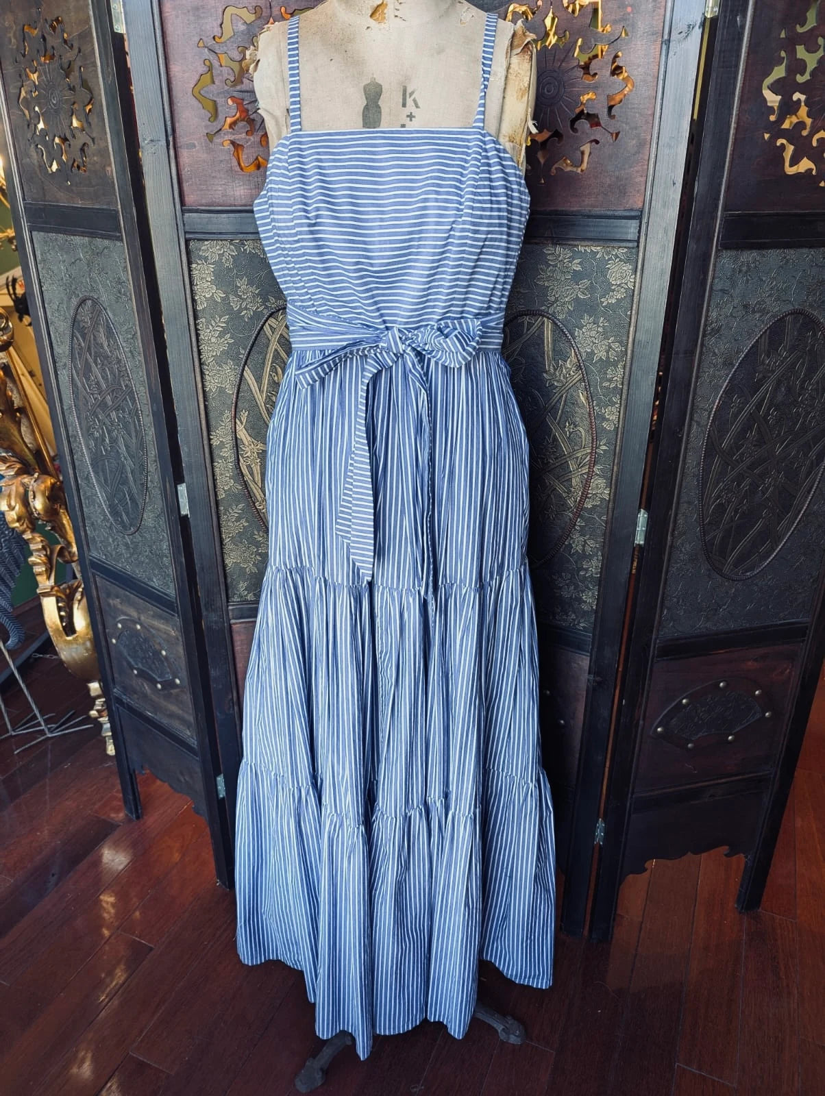 A Broochella J Crew Blue and white, cotton, striped maxi dress on a mannequin against a decorative wall.