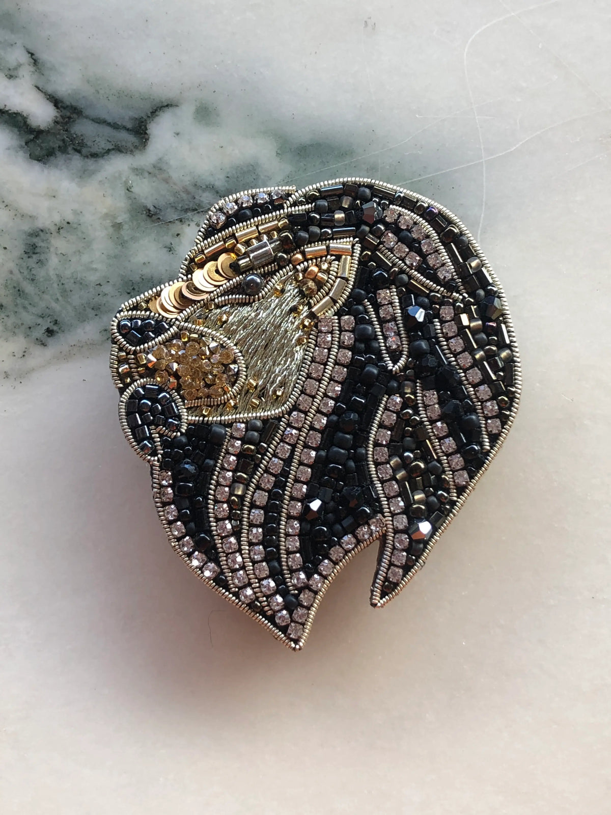 Broochella Small Lion Brooch Pin hand-beaded in black, gold and silver with crystal detailing and intricate metallic beadwork.