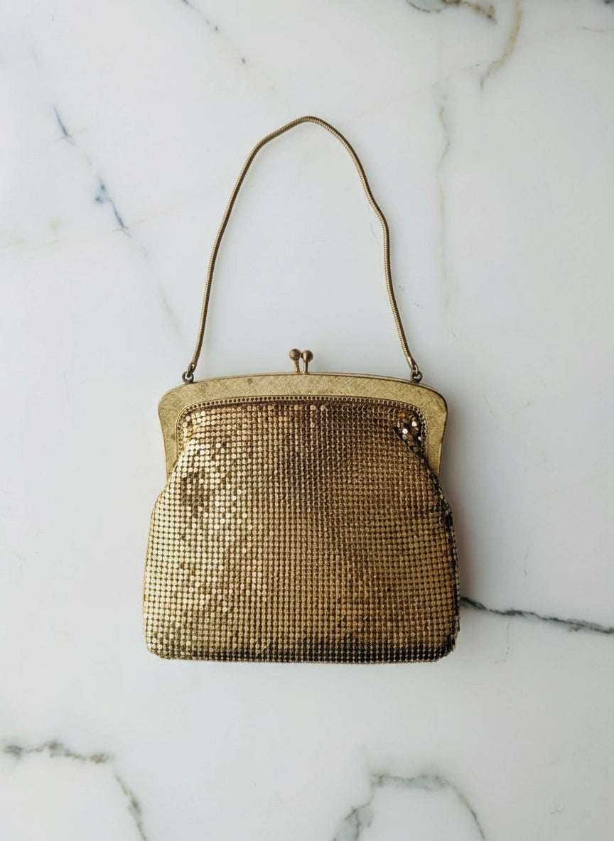 Broochella  la dame d'or oroton gold, glomesh vintage bag with vintage brooch embellishments. The background is white marble