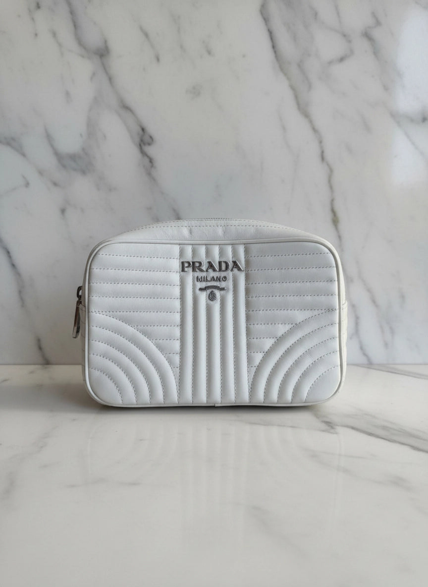 Broochella White authentic leather Prada designer camera bag purse on a white marble background
