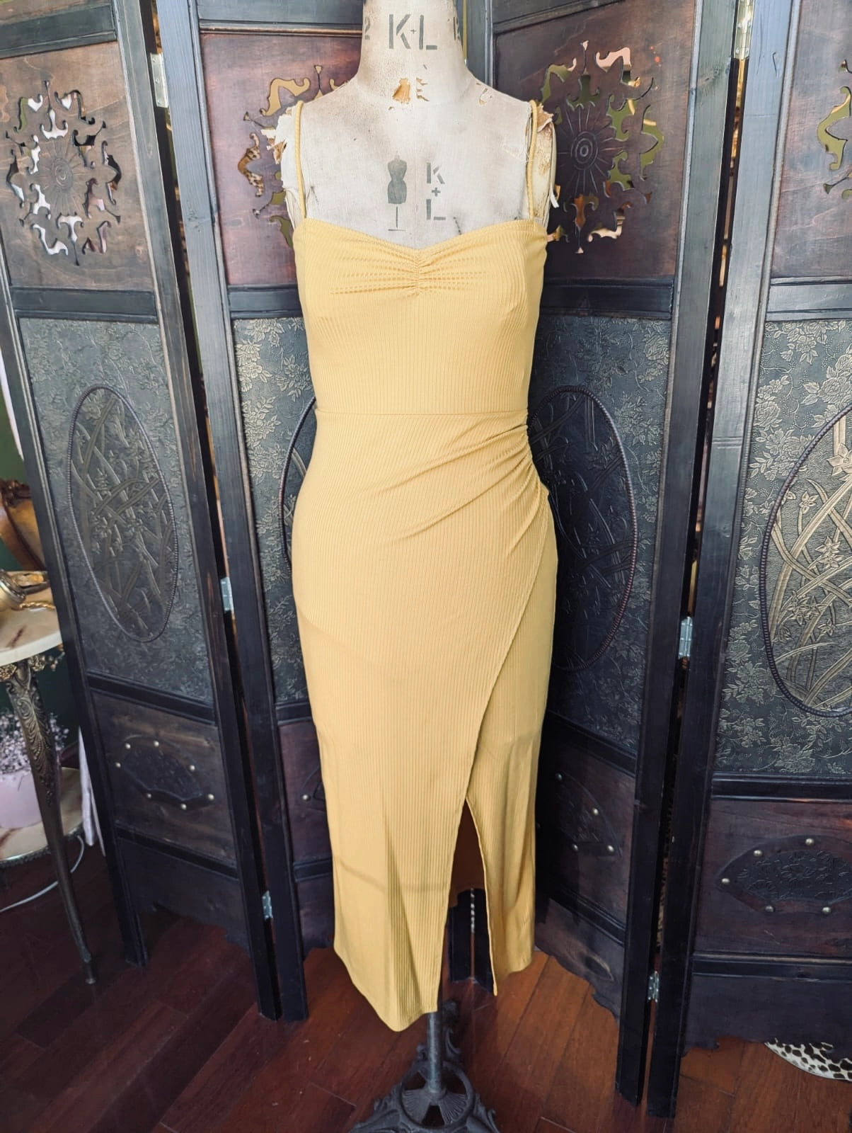 Broochella Reformation Yellow bodycon ribbed midi dress on a mannequin in front of a decorative screen