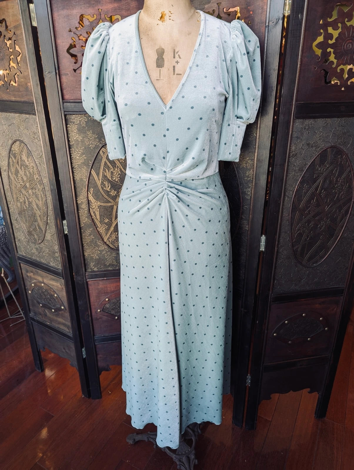 Rotate By Birger Christensen Green Velvet Polka Dot Midi Dress- UK 10. It is pictured on a mannequin. The background is an ornate dark wood room divider. 