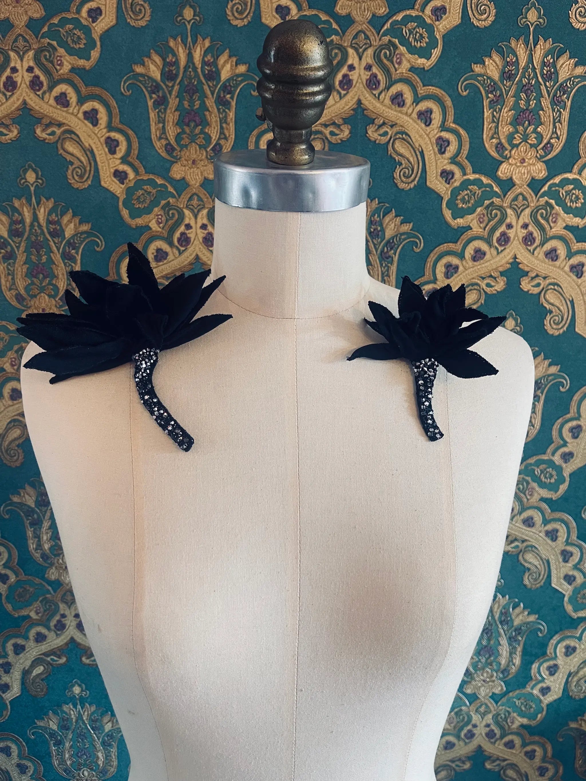 Broochella large and small Tulipano brooches. Pictured on a mannequin. The background is green and gold damask wallpaper