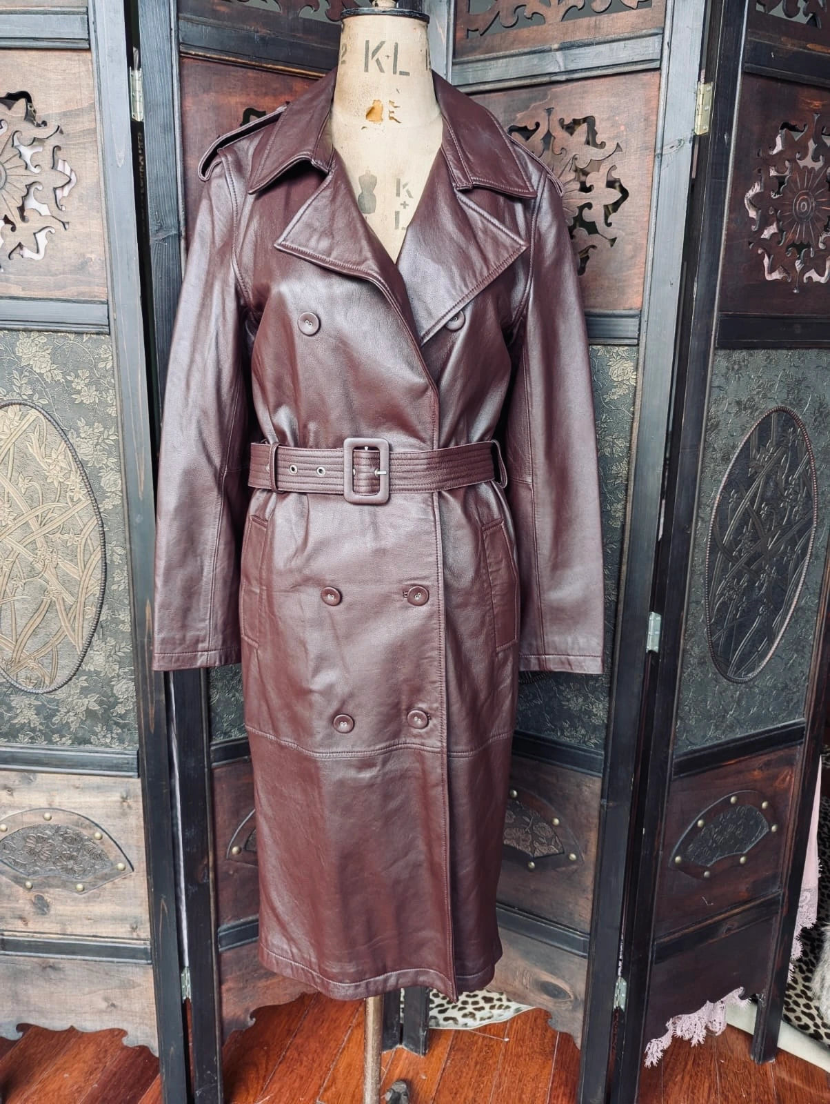 Broochella The Stylist's Closet Victoria and Woods Burgundy leather trench coat on a mannequin against an ornate wooden background