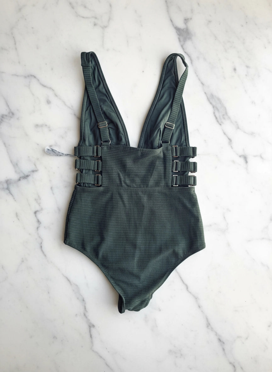 Broochella Zimmerman size 10 one piece swimsuit in green. It is pictured on a white marble surface. 