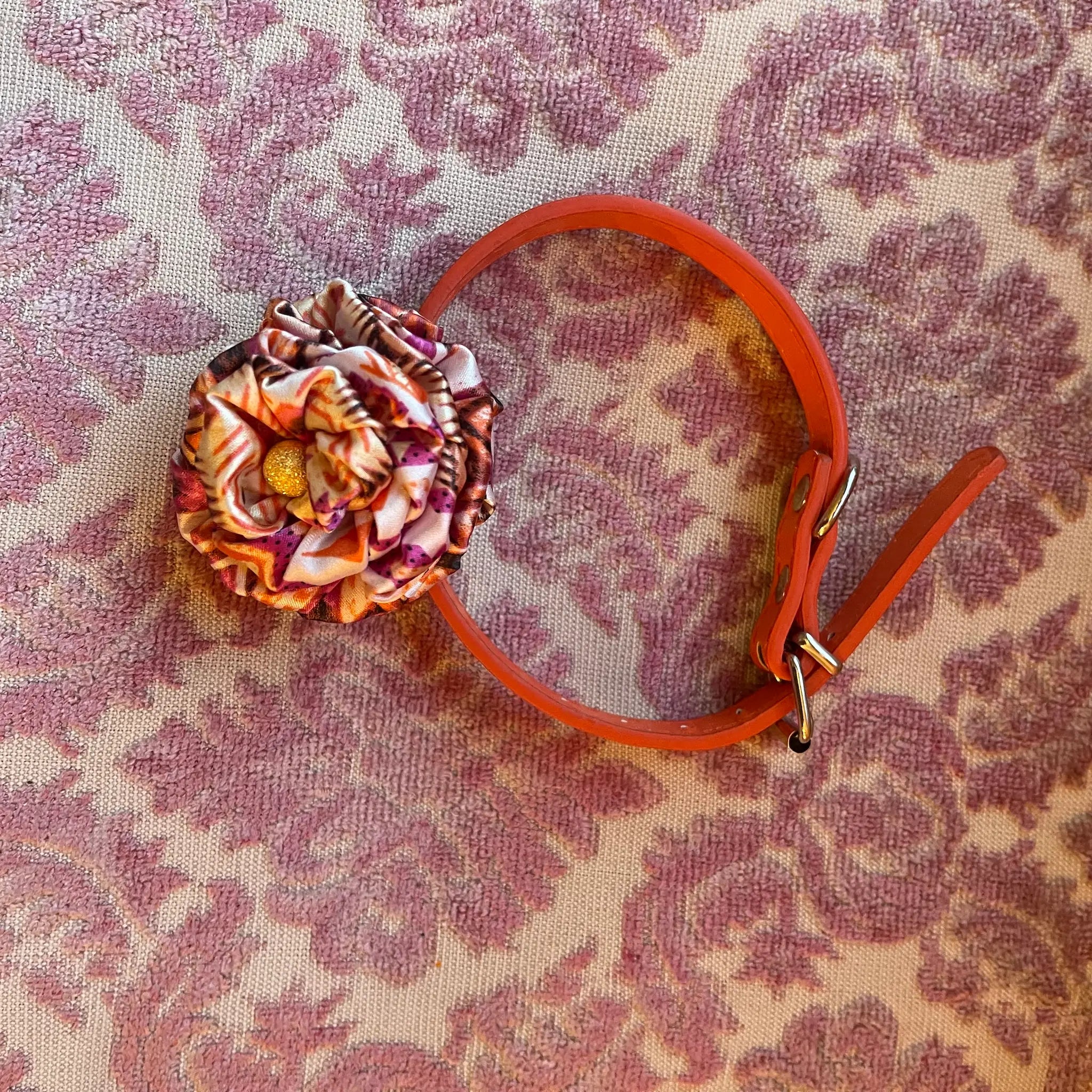 Broochella poochella bouganville capri handmade flower collar. Pictured on a pink damask background
